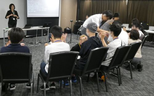 手話の動きを教えている様子