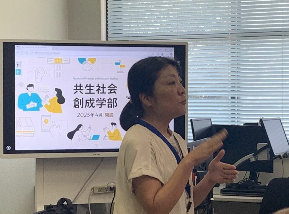 「障害社会学」の授業で手話を交えながら解説する青木先生の写真